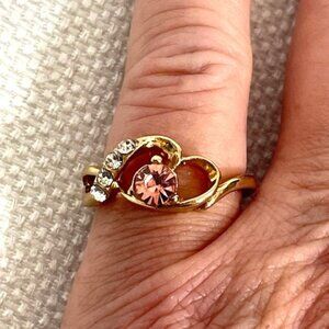 Gold-tone fashion ring with pink stone, and small "diamonds". Size 5 3/4